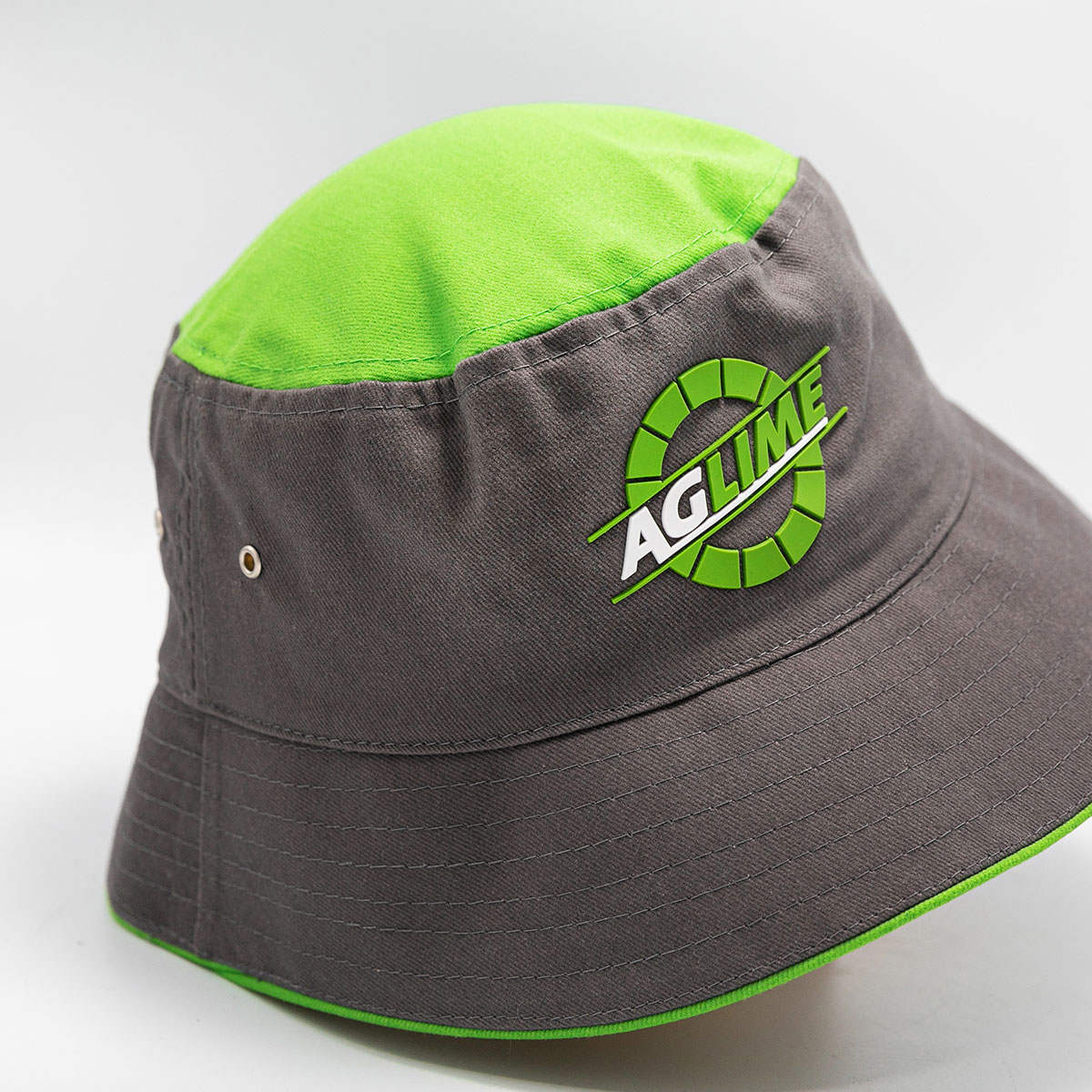 Headwear Slider Grey Bucket hat with Silicone front logo, metal eyelets, green top and trim detail